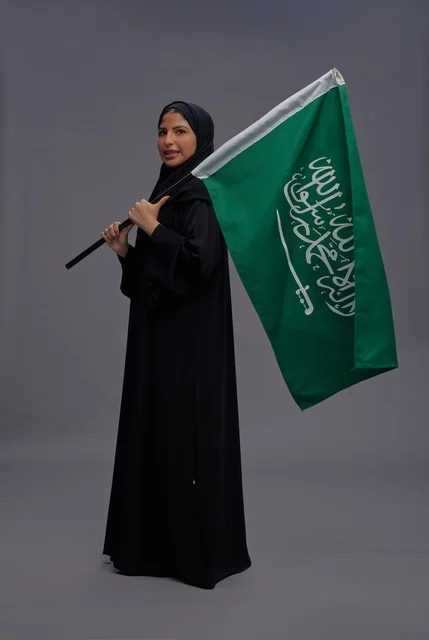 Saudi Woman in Abaya Holding National Flag in Studio