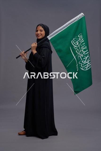 امرأة سعودية تمسك علم المملكة العربية السعودية