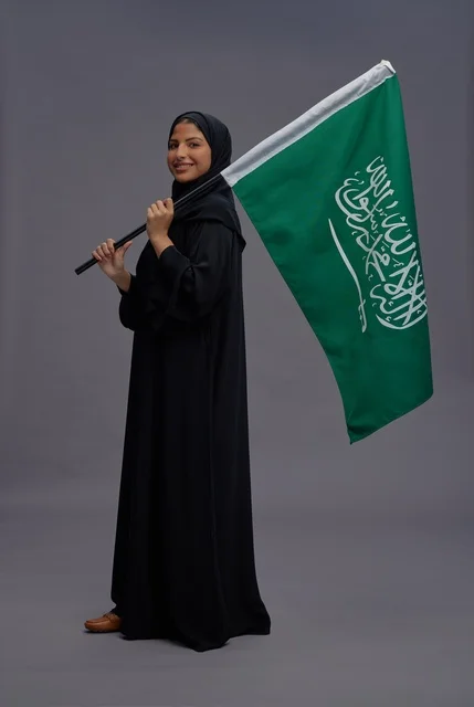 Saudi Woman Holding Saudi Arabia Flag in Studio