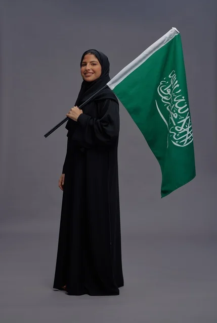Saudi Arabian Woman Holding National Flag in Studio Background