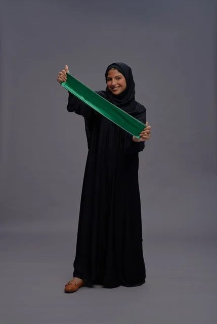 Saudi Woman Holding Green Saudi Arabia Flag in Studio