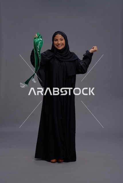 امرأة سعودية تحمل وشاح اليوم الوطني في الاستوديو