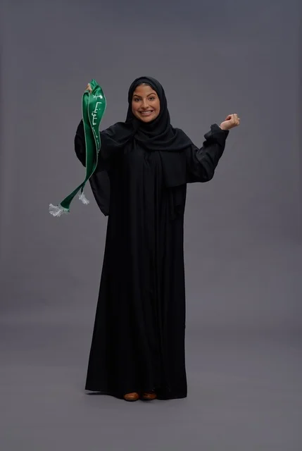 امرأة سعودية تحمل وشاح اليوم الوطني في الاستوديو