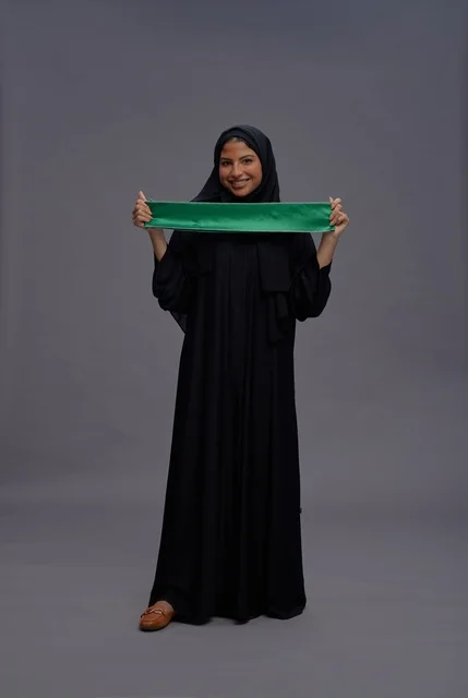 امرأة سعودية تمسك علم المملكة في الاستوديو