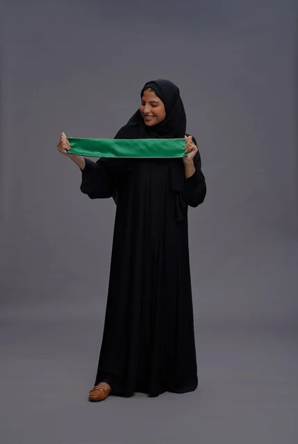 امرأة سعودية تحمل العلم الوطني في استوديو