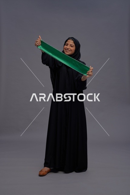 Saudi Woman Wearing Abaya Holding Green Saudi Flag
