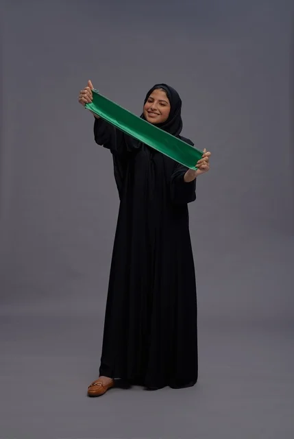 Saudi Woman Wearing Abaya Holding Green Saudi Flag