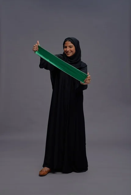 امرأة سعودية تحمل علم المملكة في الاستوديو