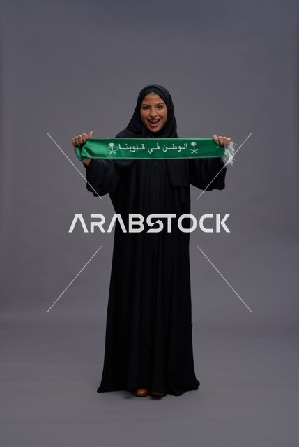 امرأة سعودية تحمل وشاح اليوم الوطني في الاستوديو