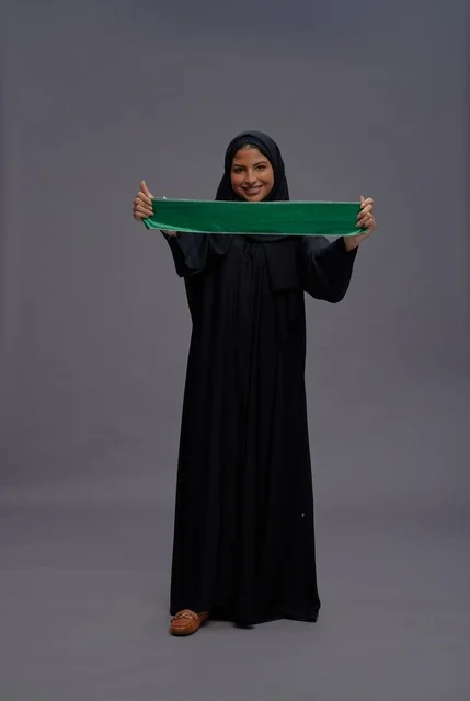 Saudi Woman in Black Abaya Holding National Flag