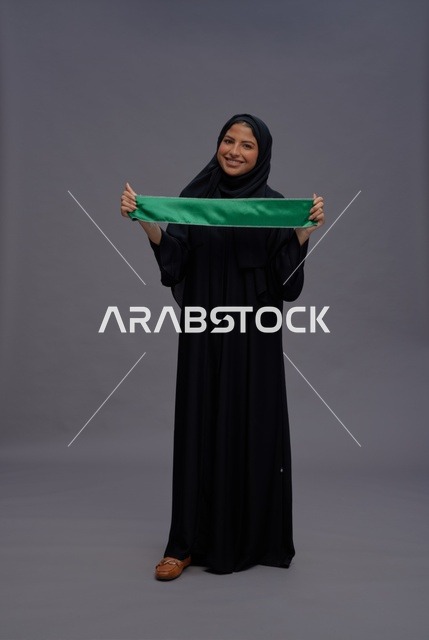امرأة سعودية تحمل علم المملكة في الاستوديو