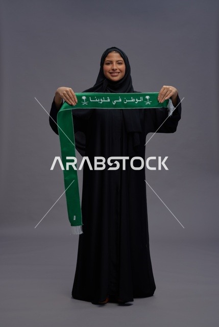 امرأة سعودية تحمل وشاح اليوم الوطني السعودي