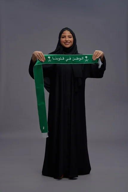 Saudi Woman Holding Green National Scarf in Studio
