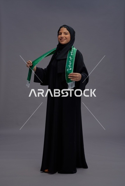 امرأة سعودية تحمل علم المملكة في استوديو
