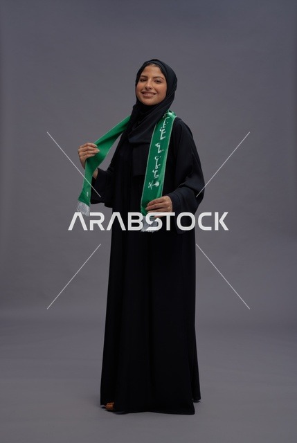 Saudi Woman in Abaya Holding National Flag Scarf
