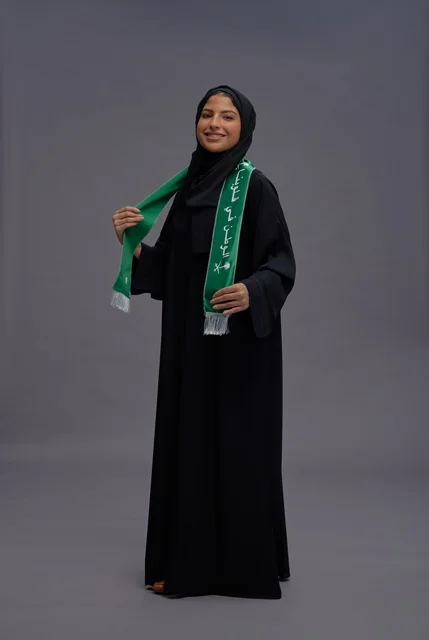 Saudi Woman in Abaya Holding National Flag Scarf