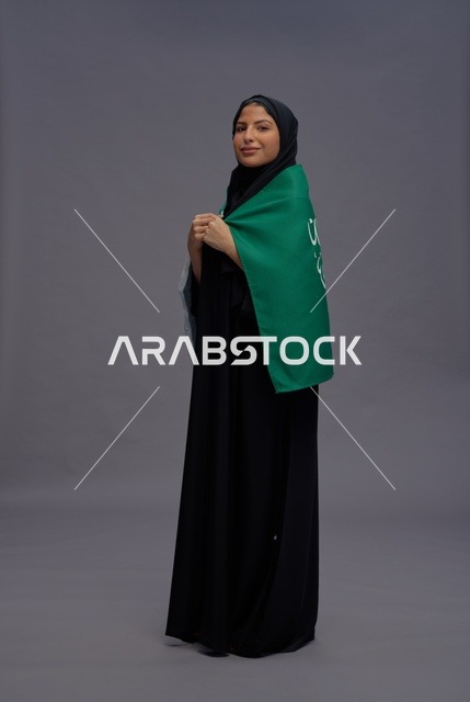 امرأة سعودية تحمل علم المملكة العربية السعودية