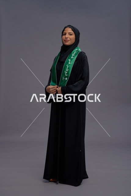 امرأة سعودية بعباية ووشاح علم المملكة العربية السعودية