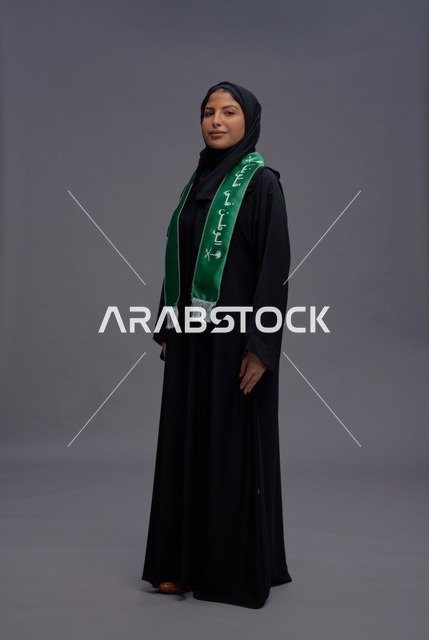 امرأة سعودية بالعباءة والوشاح الوطني في الاستوديو