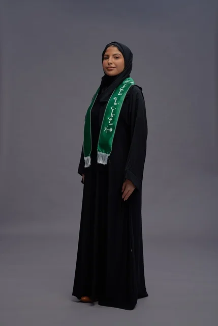 امرأة سعودية بالعباءة والوشاح الوطني في الاستوديو
