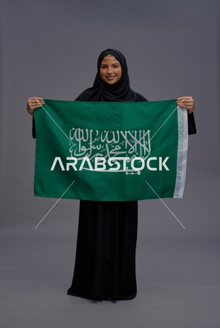 امرأة سعودية تحمل علم المملكة العربية السعودية