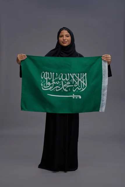 Saudi Woman Holding Saudi Arabia Flag in Studio Shot Saudi Woman Holding Saudi Arabia Flag in Studio Shot