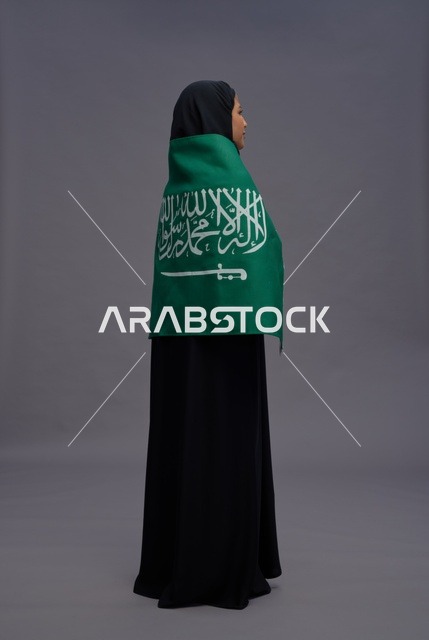 امرأة سعودية مع العلم الوطني في الاستوديو