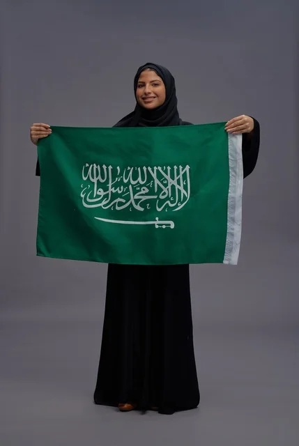 Saudi Woman Holding National Flag in Studio