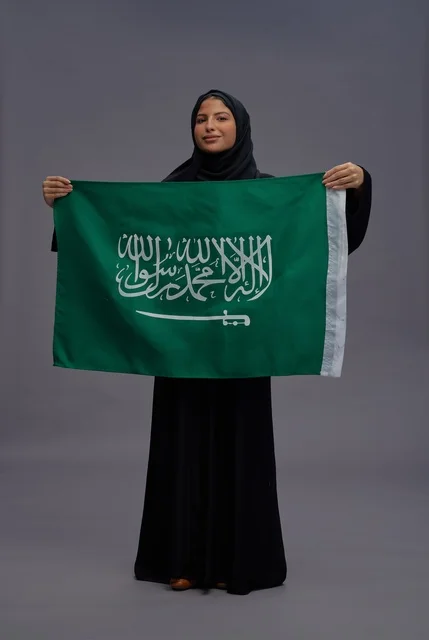 Saudi Woman Holding Saudi Arabia Flag in Studio