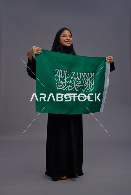 امرأة سعودية تحمل علم المملكة العربية السعودية