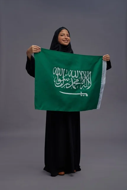 امرأة سعودية تحمل علم المملكة العربية السعودية