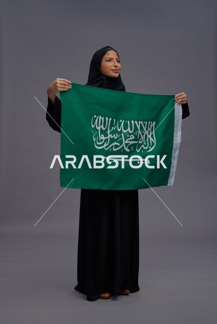 امرأة سعودية تحمل علم المملكة العربية السعودية