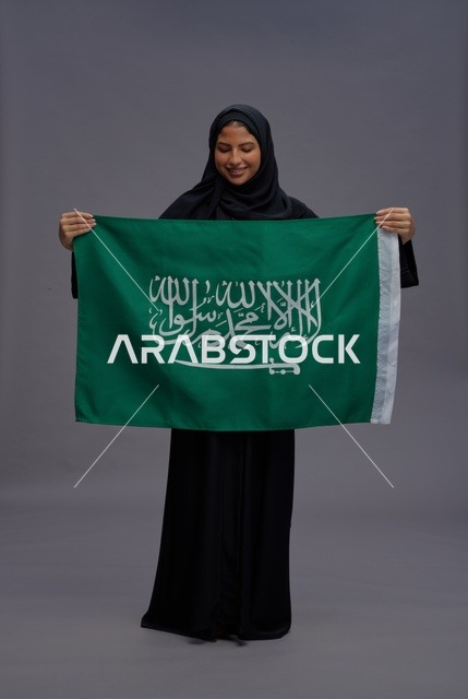 امرأة سعودية تمسك علم المملكة العربية السعودية