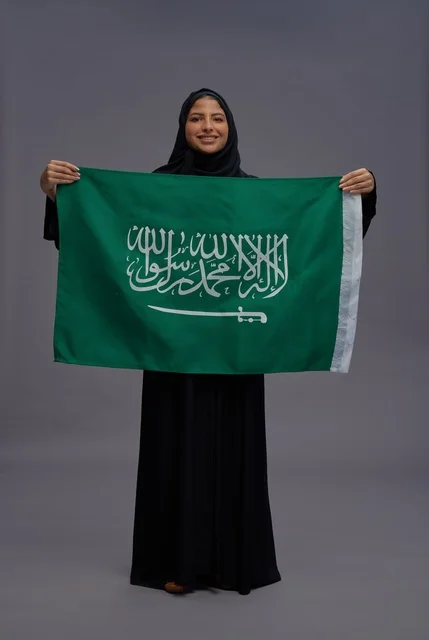 امرأة سعودية تحمل علم المملكة في الاستوديو