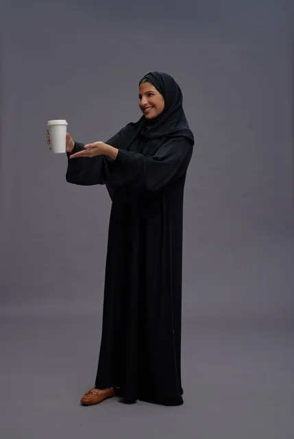 Saudi Woman in Black Abaya Holding Coffee Cup in Studio