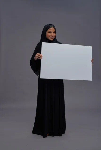 امرأة سعودية بالعباءة السوداء تحمل لوحة بيضاء فارغة امرأة سعودية بالعباءة السوداء تحمل لوحة بيضاء فارغة