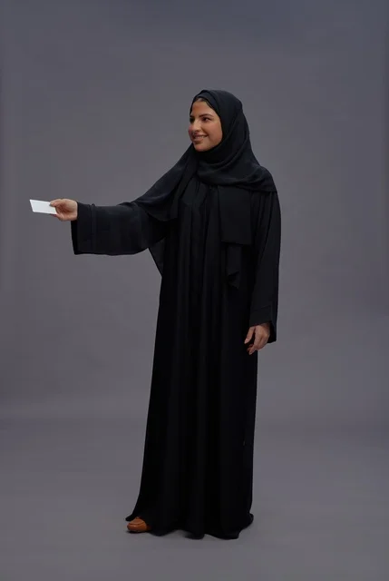 Saudi Woman in Black Abaya Holding Blank Card Saudi Woman in Black Abaya Holding Blank Card