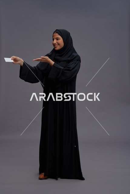 امرأة سعودية بعباية سوداء تمسك بطاقة فارغة