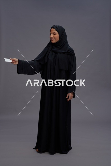 امرأة سعودية بعباية سوداء تحمل بطاقة فارغة