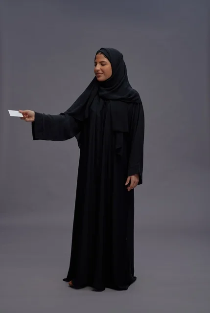 Saudi Woman in Black Abaya Holding Blank Card Saudi Woman in Black Abaya Holding Blank Card