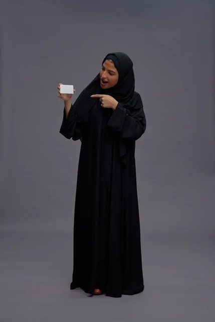 Saudi Woman in Abaya Pointing to Blank Card
