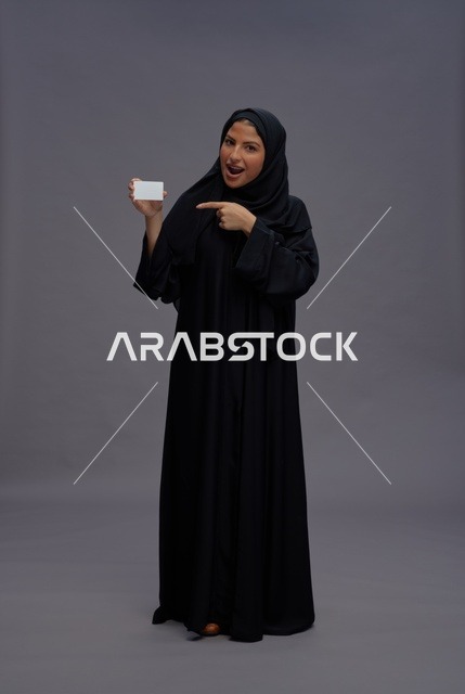 امرأة سعودية بالعباية السوداء تحمل بطاقة فارغة