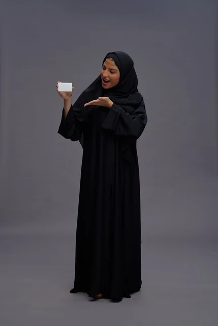 Saudi Woman in Black Abaya Holding Blank Card Saudi Woman in Black Abaya Holding Blank Card