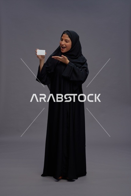 امرأة سعودية بعباية سوداء تحمل بطاقة فارغة