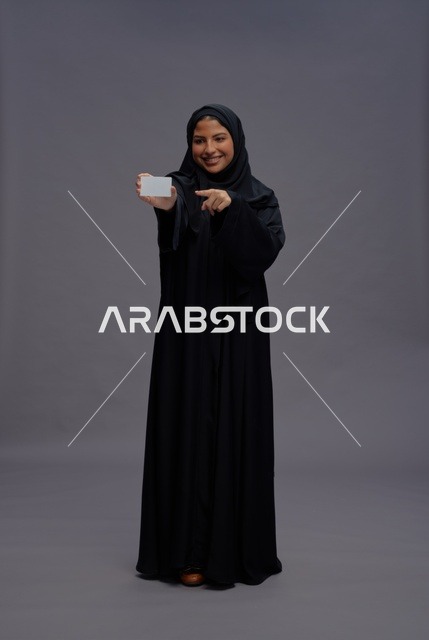 امرأة سعودية بعباءة سوداء تحمل بطاقة فارغة