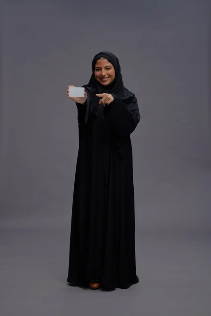 Saudi Woman in Black Abaya Holding Blank Card Saudi Woman in Black Abaya Holding Blank Card