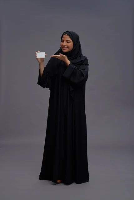 امرأة سعودية بعباية سوداء تحمل بطاقة فارغة