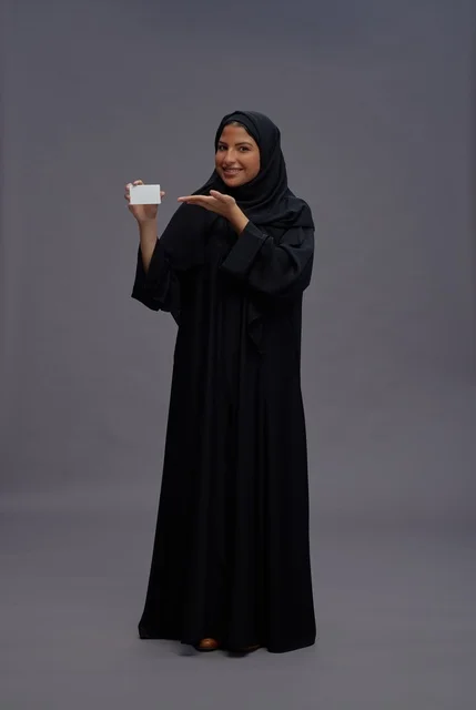 امرأة سعودية بعباية سوداء تحمل بطاقة عمل فارغة