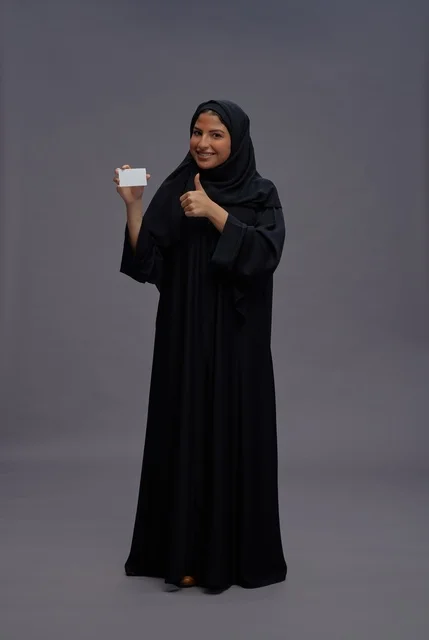 Saudi Woman in Abaya Holding Blank Card Thumbs Up