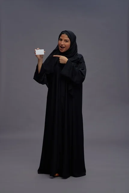 Saudi Woman in Abaya Holding Blank Card in Studio